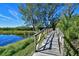 Charming wooden foot bridge over a serene pond surrounded by lush greenery and trees at 1319 Perico Point Cir, Bradenton, FL 34209