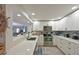 Well-lit kitchen featuring white cabinets, stainless steel appliances, and a view into the living area at 1319 Perico Point Cir, Bradenton, FL 34209