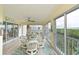 Screened lanai features a round table and chairs with tranquil water views beyond at 1319 Perico Point Cir, Bradenton, FL 34209