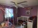 bedroom with colorful wall decor, including a bed, a crib and ceiling fan at 1423 17Th E Ave, Bradenton, FL 34208