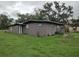 Single-story home featuring stucco exterior, green lawn, blue roof, and mature landscaping at 1423 17Th E Ave, Bradenton, FL 34208