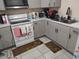 View of a kitchen featuring gray cabinets, white appliances, and laminate countertops at 1423 17Th E Ave, Bradenton, FL 34208