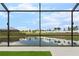 View of the fenced backyard with pond view seen through screened enclosure at 15815 Tradewind Ter, Bradenton, FL 34211