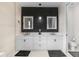 Modern bathroom features double vanity with illuminated mirrors and sleek black and white design at 15815 Tradewind Ter, Bradenton, FL 34211