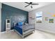 Bedroom with an accent wall with dinosaur stickers, a crib, and tiled floor at 15815 Tradewind Ter, Bradenton, FL 34211