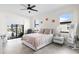 Bright bedroom featuring a ceiling fan, white walls, tile floors, modern furniture, and access to a patio with pool views at 15815 Tradewind Ter, Bradenton, FL 34211