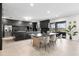 Contemporary dark kitchen with a large center island, sleek appliances, and an adjacent dining area with outdoor views at 15815 Tradewind Ter, Bradenton, FL 34211