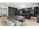 A kitchen that combines dark cabinetry, a large island with dining, and a bright adjacent space for Gathering fun at 15815 Tradewind Ter, Bradenton, FL 34211