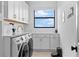Well-organized laundry room with modern washer and dryer, ample storage cabinets, and white countertops at 15815 Tradewind Ter, Bradenton, FL 34211
