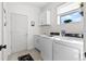 Bright laundry room with white washer and dryer, utility sink, and window offering plenty of natural light at 15815 Tradewind Ter, Bradenton, FL 34211