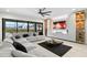 A living room featuring a large sectional couch, modern entertainment center, and sliding glass doors with backyard views at 15815 Tradewind Ter, Bradenton, FL 34211