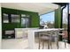 Outdoor kitchen boasts a grill, sink, mini-fridge, TV and bar seating perfect for entertaining at 15815 Tradewind Ter, Bradenton, FL 34211