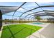 Sparkling pool with artificial turf and screened enclosure offers a refreshing outdoor retreat at 15815 Tradewind Ter, Bradenton, FL 34211