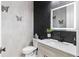 Stylish powder room featuring a decorative wall, modern vanity with a vessel sink, and a lighted mirror at 15815 Tradewind Ter, Bradenton, FL 34211