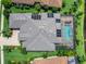 Aerial view of luxury estate featuring a private pool, solar panels, tile roof and lush landscaping at 16628 Berwick Ter, Lakewood Ranch, FL 34202
