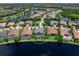 Stunning aerial view of a home with screened-in pool and lake access in a beautiful, landscaped community at 16628 Berwick Ter, Lakewood Ranch, FL 34202