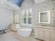 Bright bathroom featuring a soaking tub, granite countertops, and white cabinets at 16628 Berwick Ter, Lakewood Ranch, FL 34202