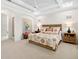 Comfortable bedroom featuring a tray ceiling, ceiling fan, and stylish decor at 16628 Berwick Ter, Lakewood Ranch, FL 34202
