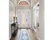 Bright foyer with a decorative glass front door, console table, and an archway entrance to another room at 16628 Berwick Ter, Lakewood Ranch, FL 34202