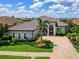 Beautiful single-Gathering home featuring a paver driveway, arched entryway, and well-manicured lawn at 16628 Berwick Ter, Lakewood Ranch, FL 34202