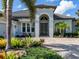 Up-close view of the home’s beautiful paver driveway, arched entryway and lush landscaping at 16628 Berwick Ter, Lakewood Ranch, FL 34202