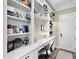 Bright home office featuring custom built-ins, a sleek white desk, and ample shelving for storage and display at 16628 Berwick Ter, Lakewood Ranch, FL 34202