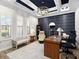 The home office features a blue accent wall, tray ceiling with chandelier and plantation shutters at 16628 Berwick Ter, Lakewood Ranch, FL 34202