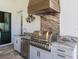 A stainless steel grill, sink, and wood vent hood make this outdoor kitchen perfect for poolside cooking and dining at 16628 Berwick Ter, Lakewood Ranch, FL 34202