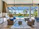 Relaxing screened-in outdoor living space features comfortable seating, a stylish rug, and views of the sparkling pool and waterway at 16628 Berwick Ter, Lakewood Ranch, FL 34202