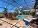 This screened pool area features beautiful landscaping, brick pavers, and comfortable lounge furniture for relaxation at 16628 Berwick Ter, Lakewood Ranch, FL 34202