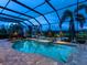 Inviting screened-in pool and spa with brick surround, palm trees, and serene views at 16628 Berwick Ter, Lakewood Ranch, FL 34202