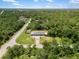 Aerial view of property showing the home, yard, and surrounding wooded area at 17211 Drayton Ln, Port Charlotte, FL 33948
