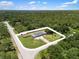 Expansive aerial view of a well-maintained home surrounded by lush greenery at 17211 Drayton Ln, Port Charlotte, FL 33948