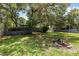 Lush backyard with mature trees and a fire pit, creating a serene outdoor space at 17211 Drayton Ln, Port Charlotte, FL 33948
