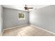 Cozy bedroom with neutral walls, tile flooring, ceiling fan, and a window providing ample natural light at 17211 Drayton Ln, Port Charlotte, FL 33948