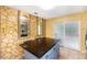 Unique kitchen with stone accent wall, granite countertop island, and sliding glass door to complete the space at 17211 Drayton Ln, Port Charlotte, FL 33948