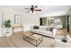 Bright living room featuring neutral tones, a ceiling fan, and seamlessly connected dining space for a modern living experience at 17211 Drayton Ln, Port Charlotte, FL 33948