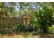 Decorative backyard well with stone accents surrounded by lush greenery and landscaping at 17211 Drayton Ln, Port Charlotte, FL 33948