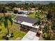 Charming home with black roof features a covered patio, spacious lawn, and lush landscaping at 211 22Nd Street Ne Ct, Bradenton, FL 34208