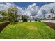 Large backyard with lush green grass, enclosed by fences, providing ample space for outdoor activities and privacy at 211 22Nd Street Ne Ct, Bradenton, FL 34208
