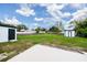 Large backyard with green grass, utility sheds, and privacy fence at 211 22Nd Street Ne Ct, Bradenton, FL 34208