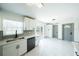 Stylish kitchen featuring white cabinets, modern sink fixtures, tile backsplash, and contemporary lighting and fixtures at 211 22Nd Street Ne Ct, Bradenton, FL 34208