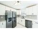Well-lit kitchen with white cabinets, modern appliances, a stylish backsplash, and a seamless transition to the dining area at 211 22Nd Street Ne Ct, Bradenton, FL 34208