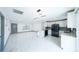 Bright open-concept kitchen and living space featuring modern lighting, white cabinetry and stainless-steel appliances at 211 22Nd Street Ne Ct, Bradenton, FL 34208