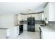 Bright kitchen featuring white cabinets, stainless steel appliances, and a modern backsplash, illuminated by contemporary lighting at 211 22Nd Street Ne Ct, Bradenton, FL 34208