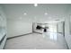 Bright living room with stylish tile flooring, recessed lighting, and an open layout connecting to the kitchen at 211 22Nd Street Ne Ct, Bradenton, FL 34208