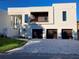 Contemporary home featuring a three-car garage, neutral stucco, and meticulous landscaping at 2110 Michele Dr, Sarasota, FL 34231