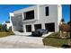 Modern house exterior with a gray sports car parked in front of the garages at 2110 Michele Dr, Sarasota, FL 34231