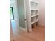 Hallway with wood floors leading to a frosted glass door and closet with custom shelving at 2110 Michele Dr, Sarasota, FL 34231