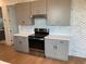 Well-equipped kitchen with stainless steel appliances, gray cabinetry, and elegant backsplash at 2110 Michele Dr, Sarasota, FL 34231